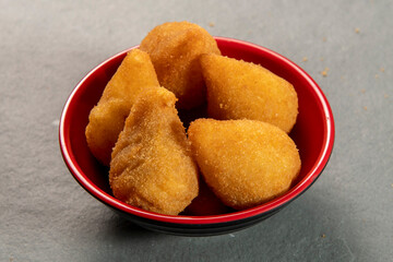 traditional fried coxinha in plate on slate background, popular brazilian snack