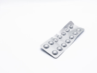 A plastic blister-wrapped medicine is crumpled on a white background. Several packages of medicine are ripped off and there is a lot of empty space and copy space on one side.