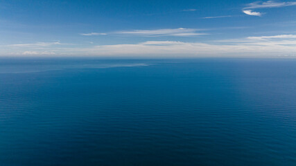 Aerial drone of open blue sea with waves against the sky and clouds. Seascape in the tropics. Borneo, Malaysia.