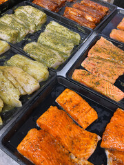 Assorted marinated salmon fillet pieces now available at the fish market