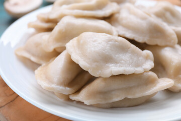 Delicious dumplings (varenyky) with potatoes on plate, closeup
