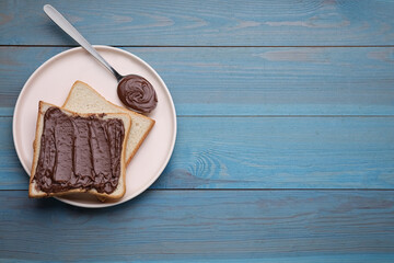 Tasty breakfast. Bread with chocolate paste served on light blue wooden table, top view. Space for text