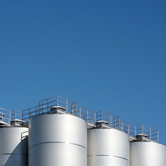 Big industrial silos under blue sky © Jack