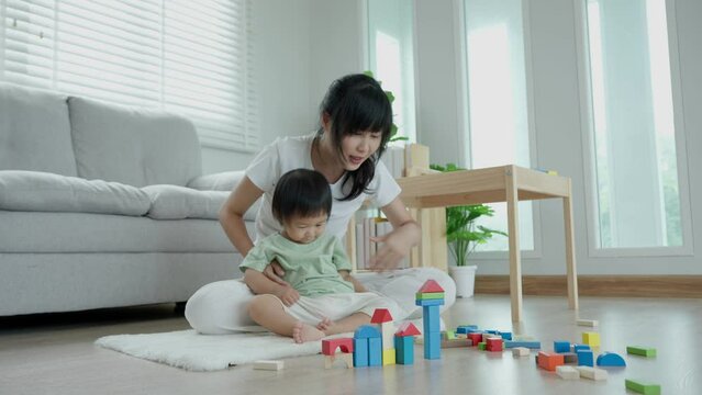 Happy Asia mother play and learn toy blocks with the little girl. Funny family is happy and excited in the house. Mother and daughter having fun spending time together. Holiday, Activity, development