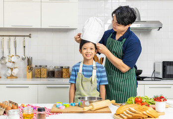 Adorable son doing cooking training in  kitchen room.