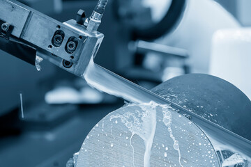Close up scene the operation of band saw cutting machine cutting the metal shaft parts with coolant...
