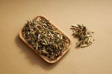 Chinese motherwort on wooden dish displayed on beige background. Chinese motherwort (Leonurus...