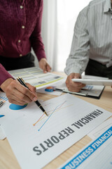 A group of Asian businessmen are brainstorming to analyze financial reporting situations. Calculate investments, income, taxes, accounts from data reference graphs. Income from laptop at office desk.