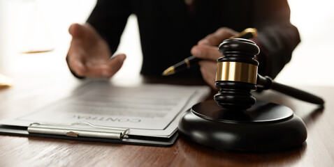 Female lawyer or legal advisor holding pen on desk and explaining Negotiate contracts and business agreements in a law firm. justice concept.