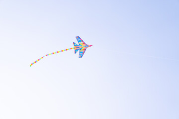 A color kite flying against a blue sky. Kite flying in the sky among the clouds