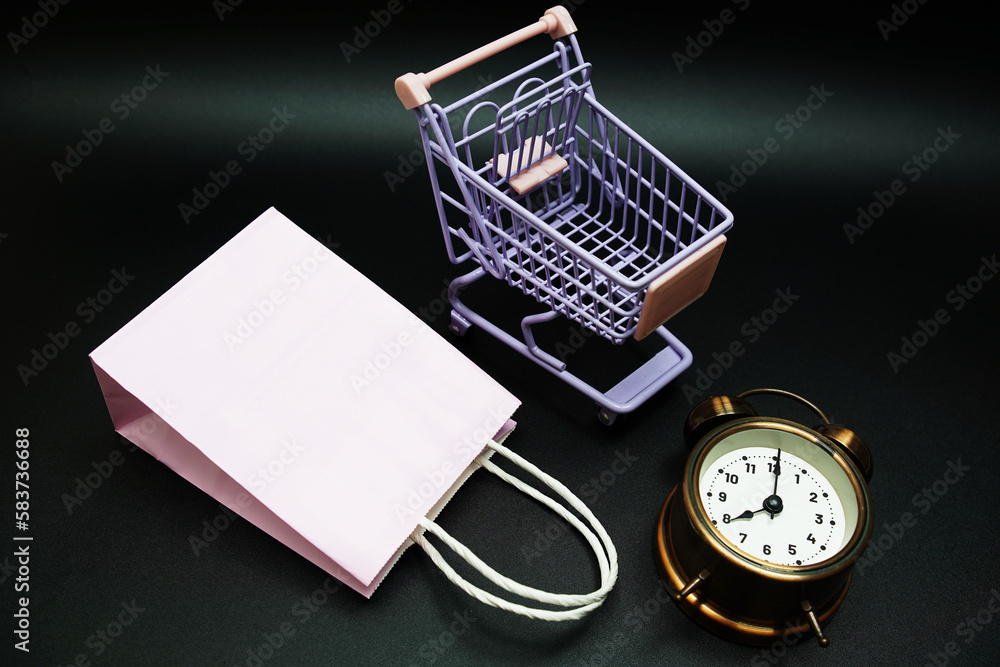 Poster trolley cart and shopping bag with alram clock with space copy on black background