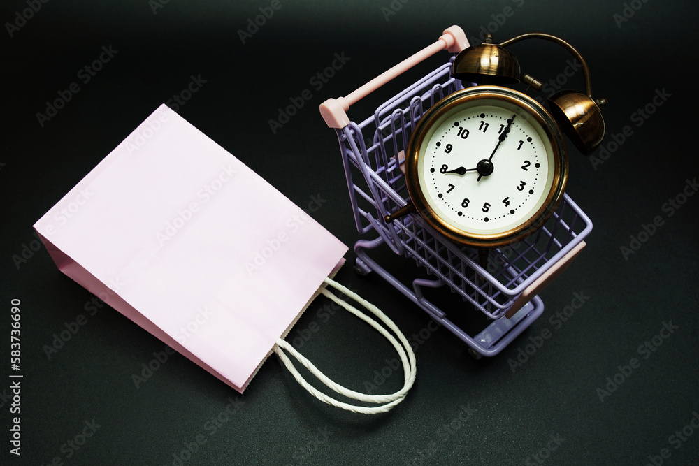 Poster trolley cart and shopping bag with alram clock with space copy on black background