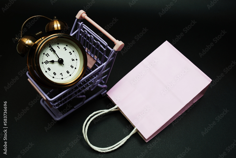 Poster trolley cart and shopping bag with alram clock with space copy on black background