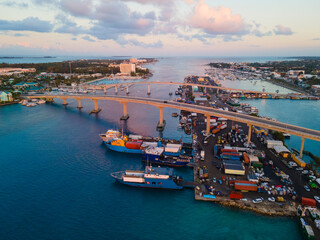 Nassau downtown sunset aerial view including Paradise Island Bridge and Potters Cay in Nassau Harbour, New Providence Island, Bahamas. 