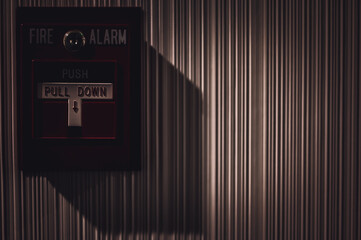 Selective focus on a wall mounted fire alarm switch in a empty hallway