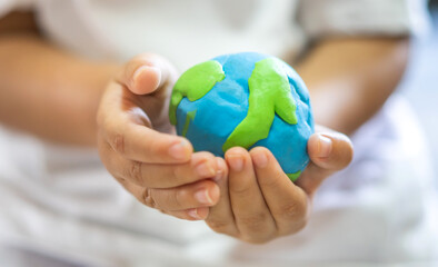 Hand of kid child holding planting saving clean energy earth globe world environment green eco friendly.campaign save the earth and earth Day 22 April