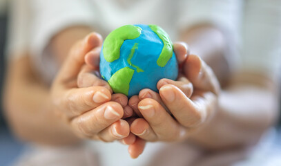 Fototapeta Hand of mother and kid child holding planting care saving clean energy earth globe world environment green eco friendly.campaign save the earth and earth Day 22 April obraz