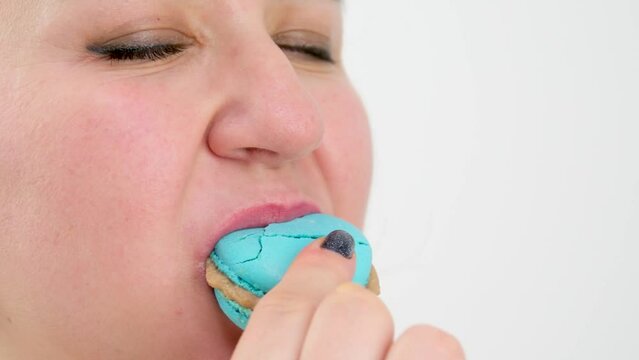 Cooking, confectionery, food and baking concept. Traditional french colorful macaroons. Sweet meringue-based confection. Woman with delicacy macaroon. Pastry macaroon. Girl eat tasty macaroon