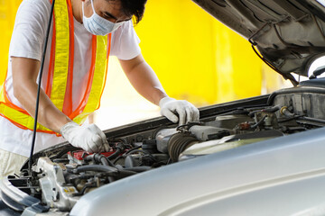 Asian mechanic examining the car's symptoms.service concept
