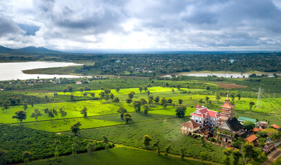 Naklejka premium Aerial view of an ancient pagoda in the middle of a green tea field in Pleiku town, Gia Lai province, Vietnam