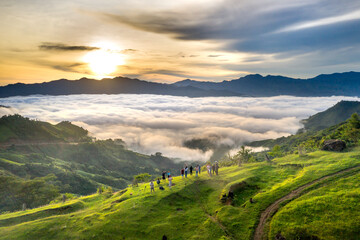 Panoramic view of sunrise with a trail going through a valley filled with white clouds in the Tak...