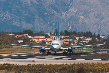 Fototapeta na wymiar View of modern passenger plane aircraft on an runway airfield ready to take off, airstrip with commercial airplane before take off or after landing, airliner with mountains in a summer day