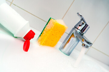Cleaning plumbing with cleaning products, glove sponge and plumbing.