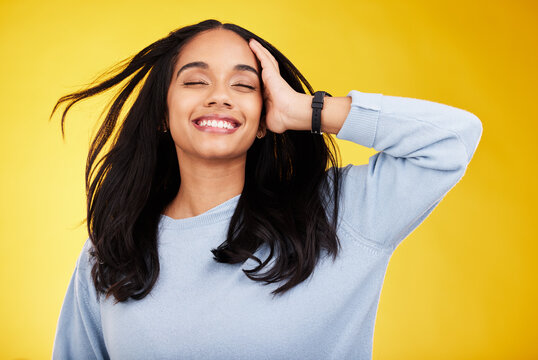 Happy, freedom and relief with a woman on a yellow background in studio feeling carefree or cheerful. Smile, relax and calm with an attractive young female posing eyes closed in a peaceful mood