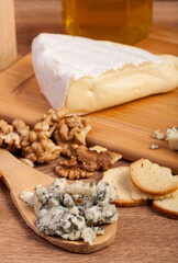 Dor blue and white cheese with nuts and honey on vintage wooden background in studio photo