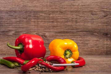 Sweet pepper and chili on wooden background in studio photo. Raw healthy food