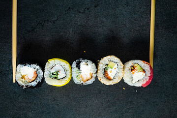sushi with chopsticks on the black background