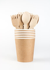 Wooden forks and spoons in a paper cup. Eco-friendly disposable kitchen utensils on a white background. Zero waste concept.