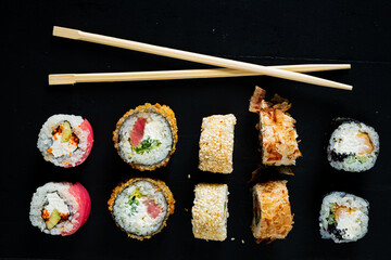 sushi with chopsticks on the black background