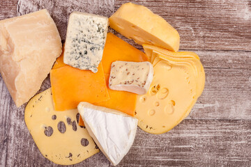 Plate with cheese on top view on wooden background in studio photo