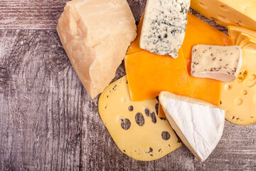 Plate with cheese on top view on wooden background in studio photo