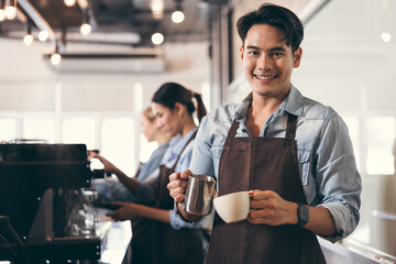 Happy barista Asia man make coffee with team work background at coffee shop	