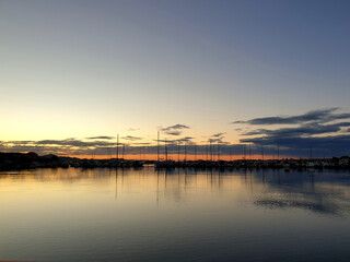 Fototapeta premium sunset sky over water with boats in marina 