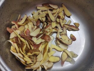 Potato peelings are in the kitchen sink. A lot of peel from raw vegetables.