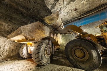 Mining load truck being filled with ore by an excavator underground in a mine site in Australia © Michael Evans