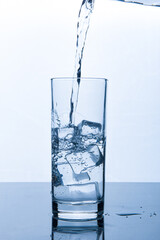 drinking water pouring into glass with ice