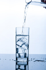 drinking water pouring into glass with ice