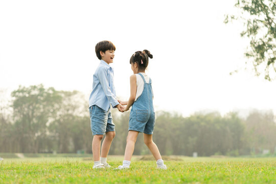 image of brother and sister having fun in the park