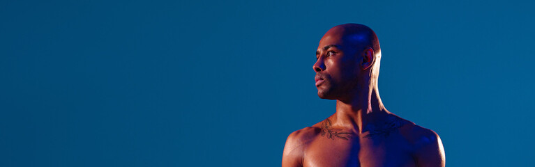 Muscular man doing exercise with weight dumbbells on studio background. Strength and motivation