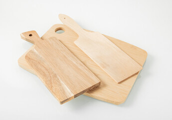 Wooden kitchen utensils.Three cutting boards on a light background