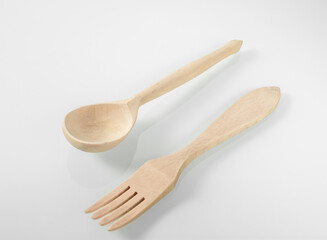 Wood kitchen utensils. Wooden spoon and fork on a white mirror background