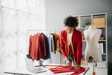 Diverse female fashion designers at work with tailor centimeters on necks and holds tablet and smartphone. independent creative design business. .