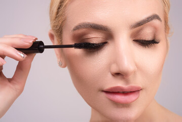 Female model shaping eyelashes. Woman eye with beautiful eyelashes. Perfect shaped lashes with brush. Paint eyelashes.