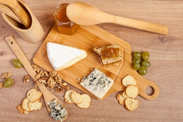 Fototapeta na wymiar Over top view of healthy, gourmet food. Healthy food. Differet type of cheese on white wooden background.
