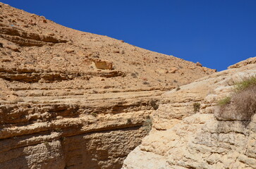 Fototapeta premium Beautiful rocks and canyons in the wild nature and the dry desert of Wadi Ghweir in Jordan on a bright sunny day