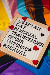 LGBTQIA description frame on Rainbow LGBTQIA flag made from silk material. LESBIAN, GAY, BISEXUAL,...